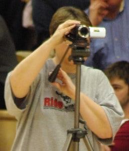 Woman with a video camera on a tripod