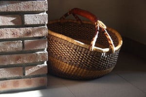 In a home, a basket sits in the sunlight.