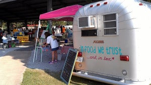 An airstream trailer with a pink awning, food sales at an event