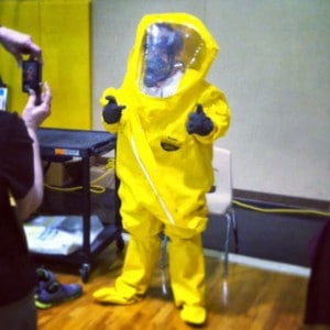Kid in a haz mat suit gives two thumbs up