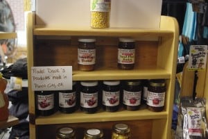 A small shelf unit in a retail store with locally made jams