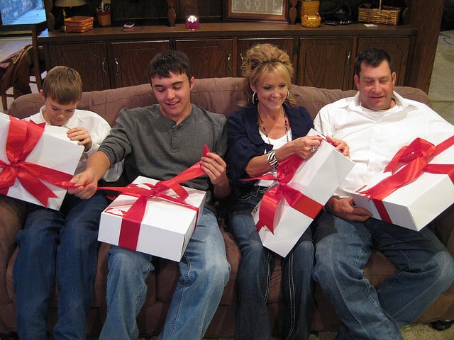 A family opens big gift boxes. 