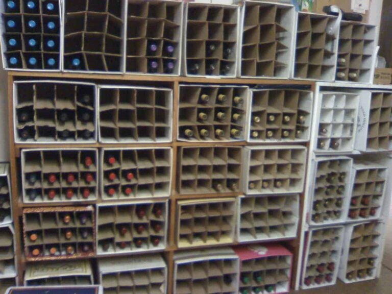 Book shelves with divided cardboard boxes filled with wine bottles