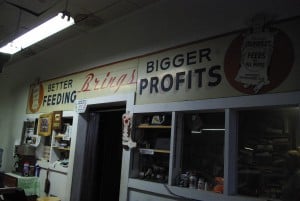 A sign in an old-fashioned feed store says "better feeding brings bigger profits"