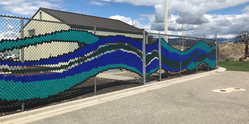 Chain link fence made into a mural of a stream
