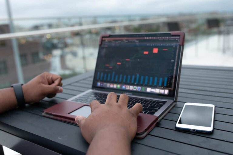 A person is working on a laptop from a rooftop deck
