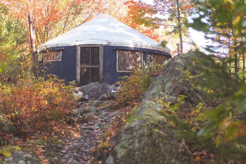 A modern camping yurt on a rocky hill in the autumn