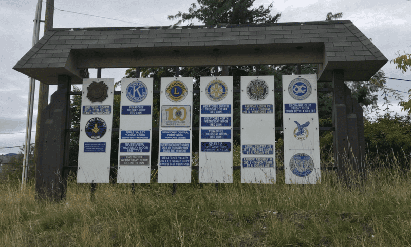 Civic and fraternal organization signs posted together at the edge of town.