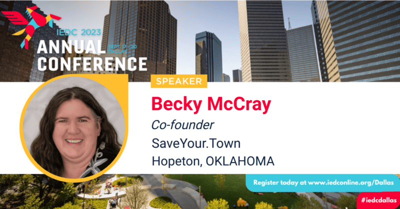Speaker badge for IEDC Annual Conference with a headshot speaker Becky McCray, and a background of the Dallas Texas skyline. 