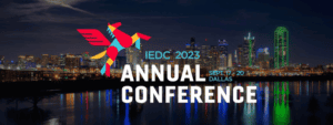 IEDC 2023 annual conference logotype over a nighttime skyline of Dallas, Texas.