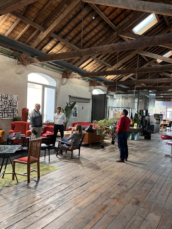 Several people preparing for a panel presentation in a coworking space in Portugal