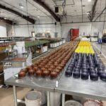 A stainless steel table covered with candles in progress
